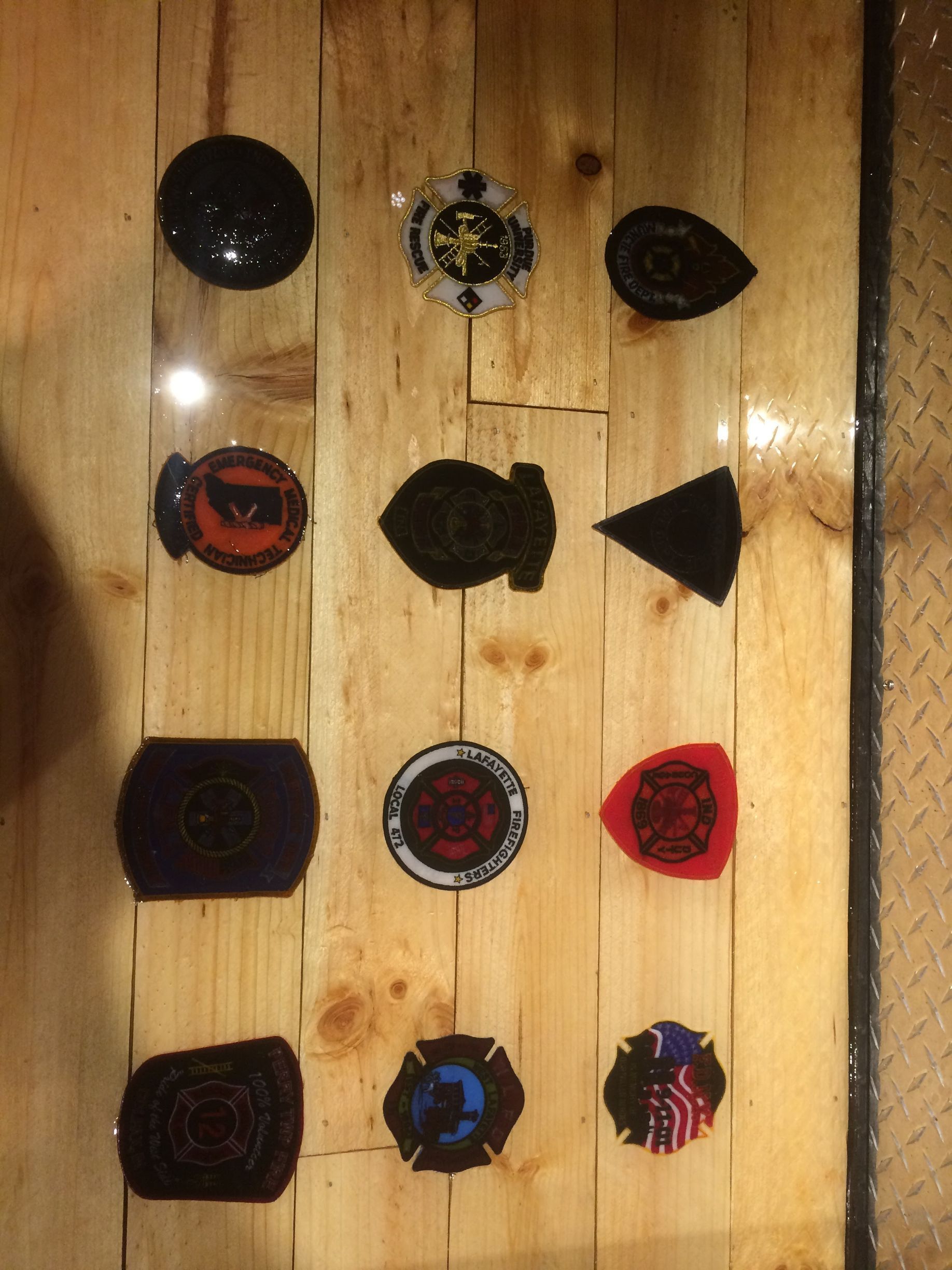 Assorted colorful pinback buttons arranged in rows on a wooden surface.