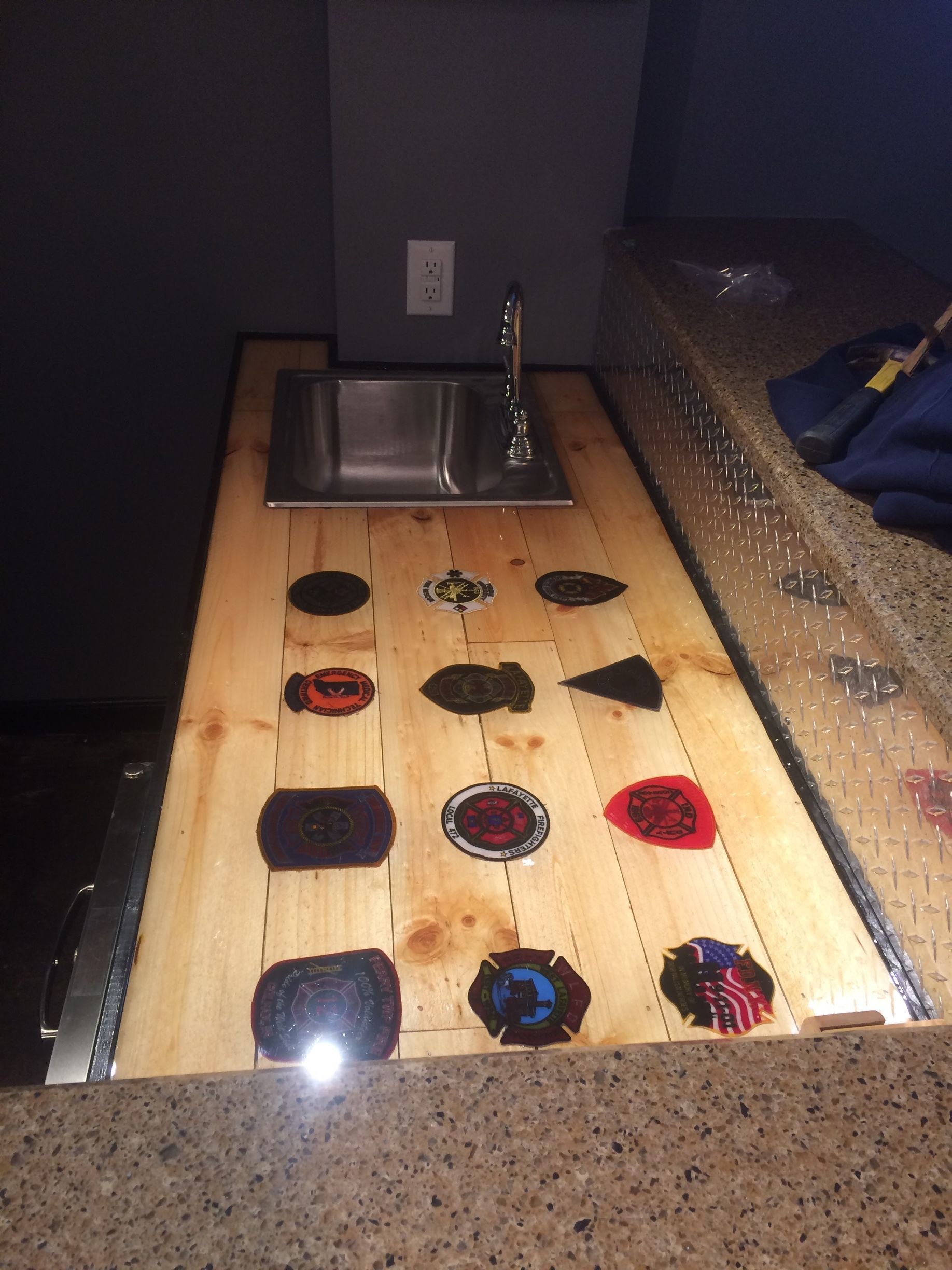 Wooden game table with a sink and colorful circular and triangular game pieces under clear cover