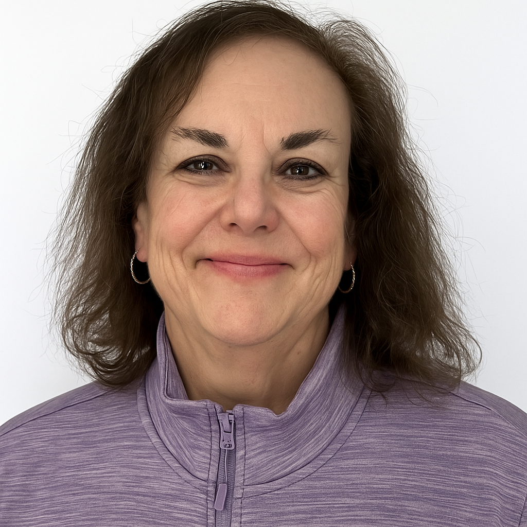 A woman wearing glasses and earrings is smiling for the camera.