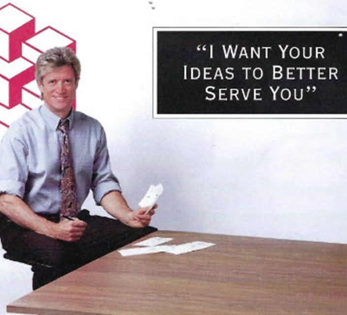 Man at table with cards; sign says