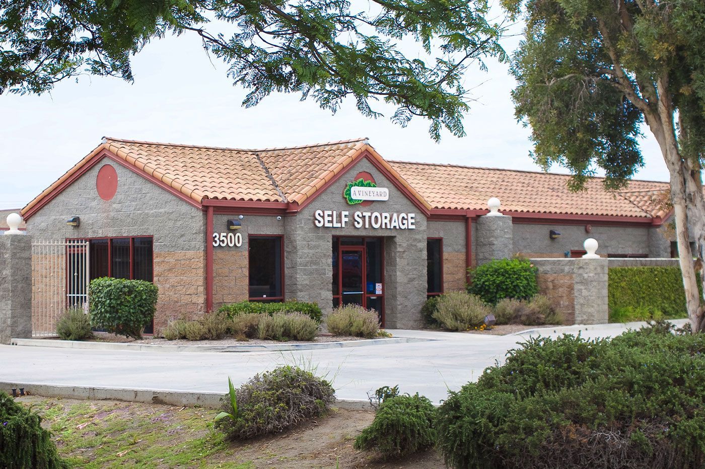 Self-storage facility with a brick facade, tile roof, and sign.