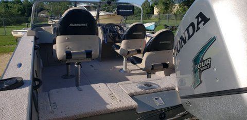 Small fishing boat deck with seats and a Honda outboard motor on a sunny day