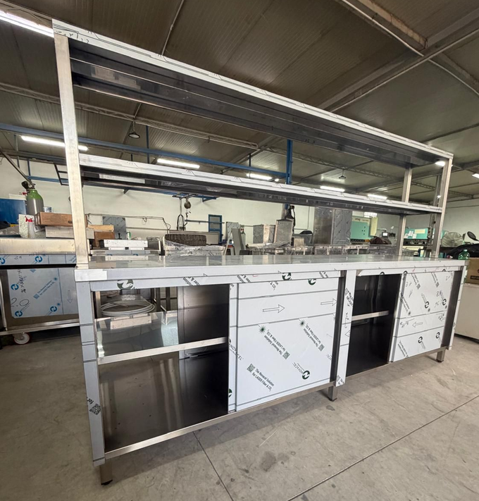 Tavolo da lavoro professionale in acciaio inox con ripiani, ideale per cucine industriali.