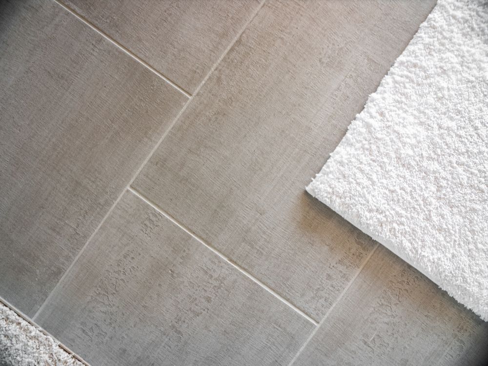 Gray tiled floor with white towel.