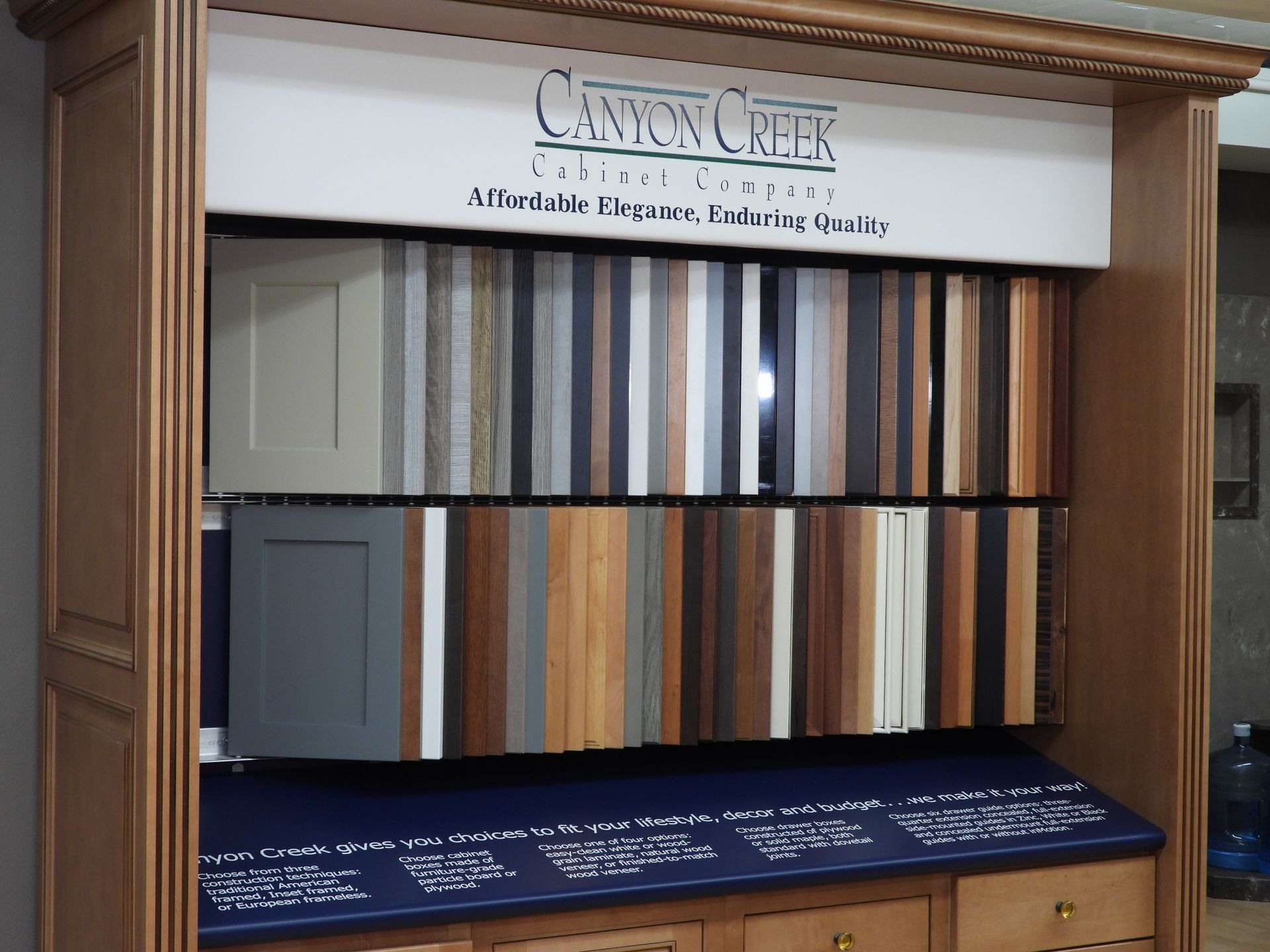 Cabinet display of wood, metal, and paint finish samples with a sign reading “Canyon Creek”