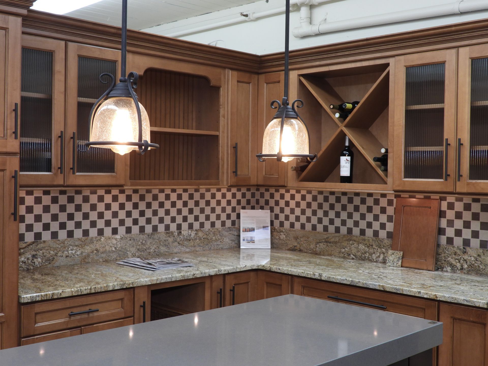 Modern kitchen with wooden cabinets, granite countertops, pendant lights, and a checkered tile backsplash