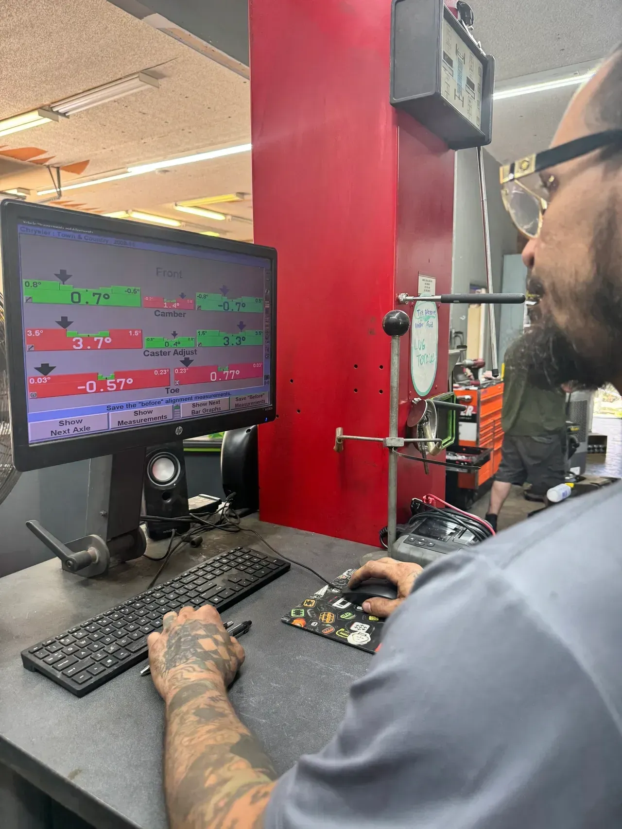 Person at a computer in a red-walled workspace, viewing a monitor with colorful code-like lines. | RMP Auto