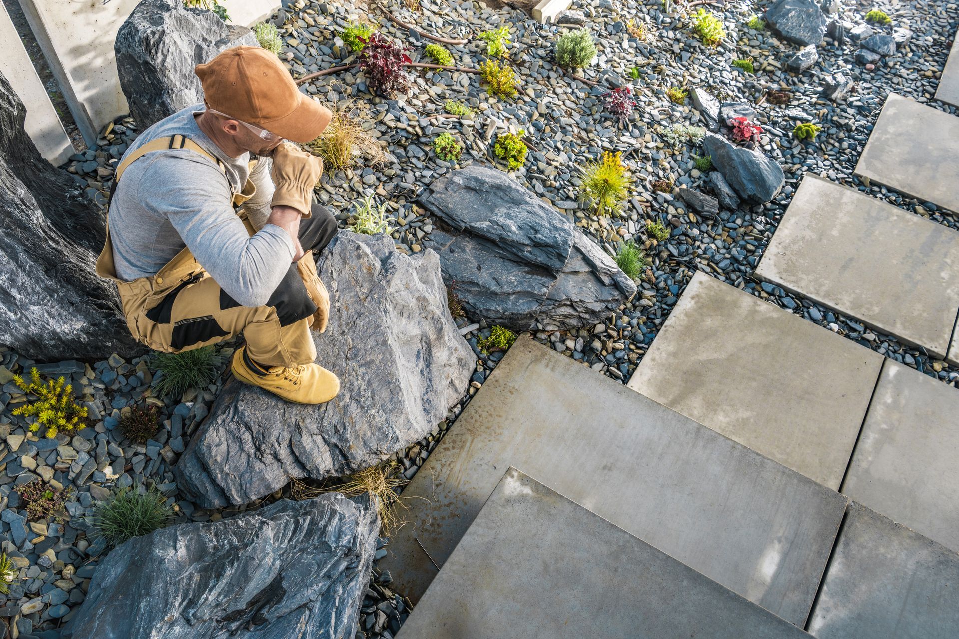 A man is sitting on a rock in a rock garden.