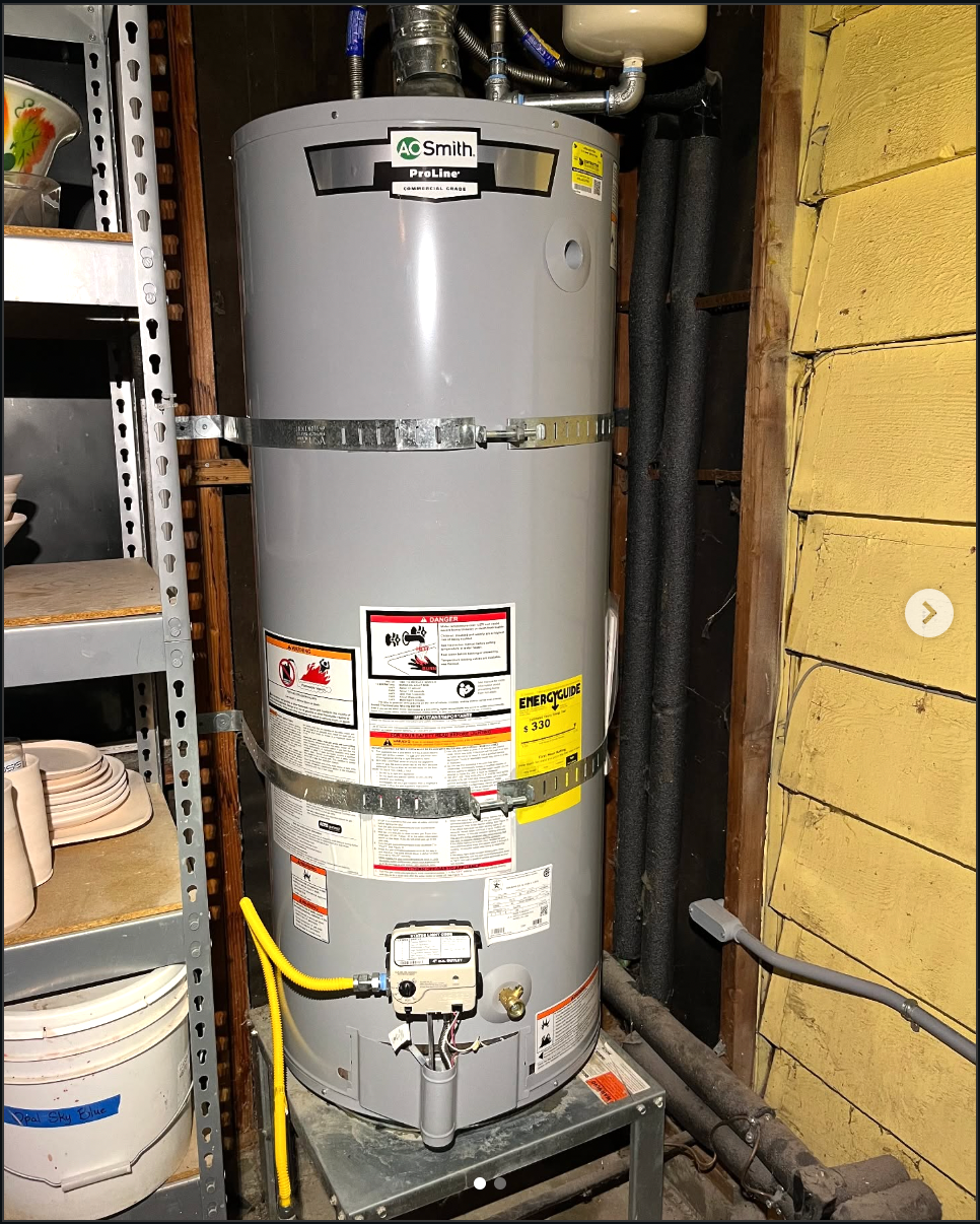 Vinney installing a water heater in a Tacoma-area home utility space