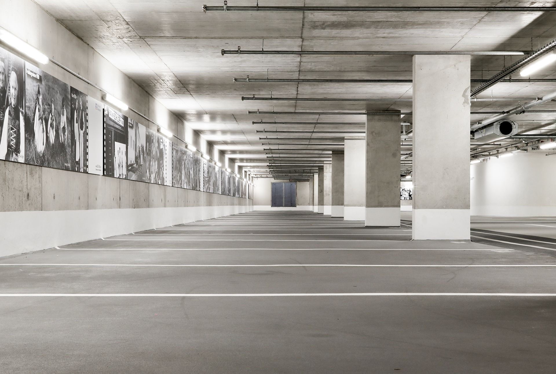 Leere Parkgarage aus Beton, mit Stützpfeilern und schwarz-weißen Kunstwerken.Fotograf Tübingen. Fotograf Reutlingen.