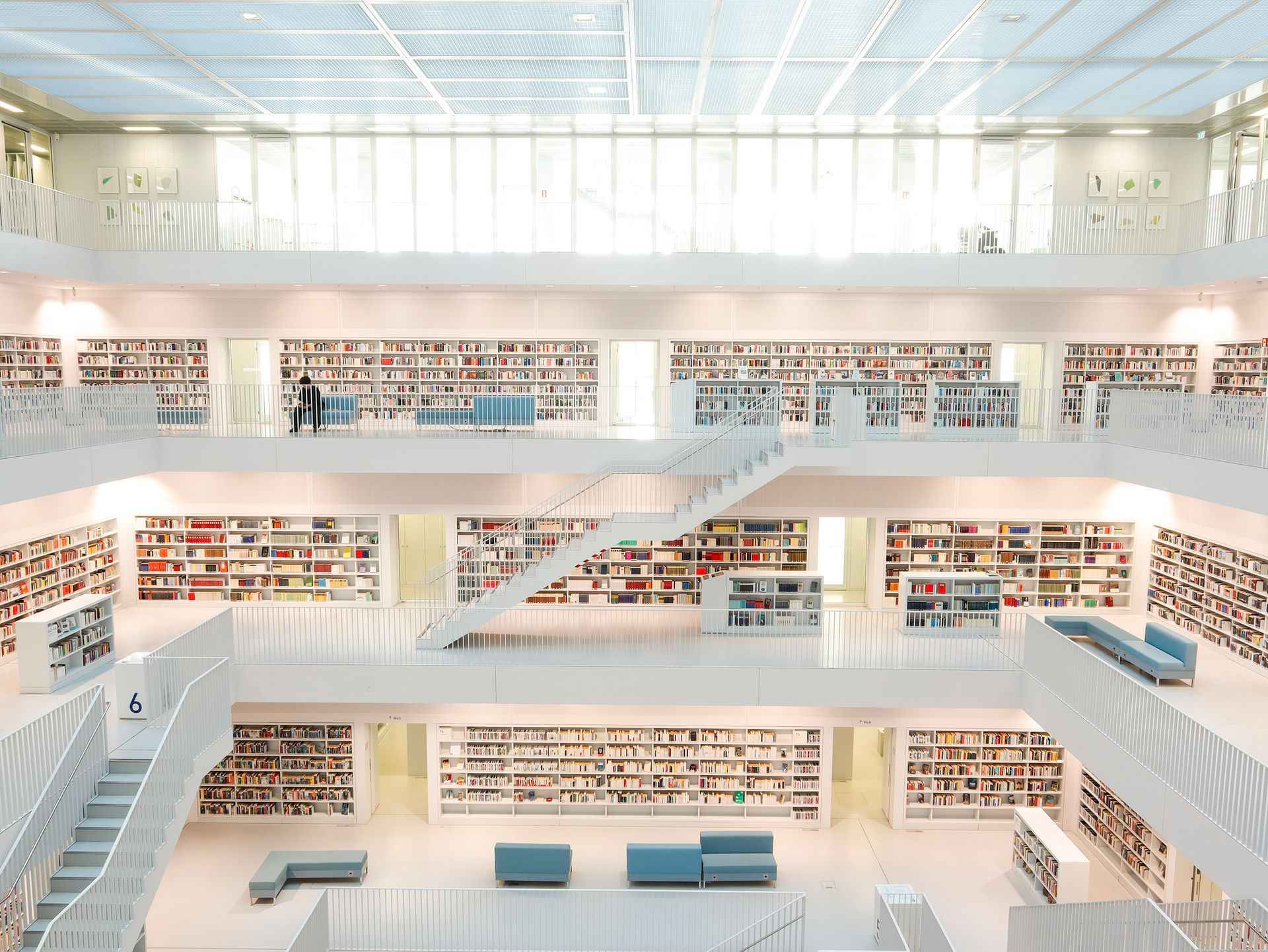 Innenansicht moderner Bibliothek mit weißen Böden, Bücherregalen und mehreren Ebenen.Fotograf Tübingen. Fotograf Reutlingen.