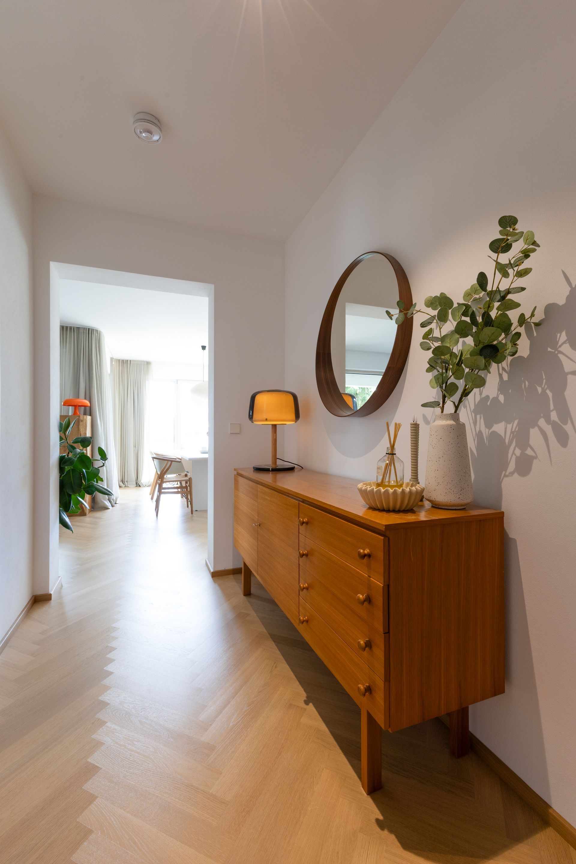Eingangsbereich mit Kommode, rundem Spiegel und Vase. Holzboden und weiße Wände.Fotograf Tübingen. Fotograf Reutlingen.