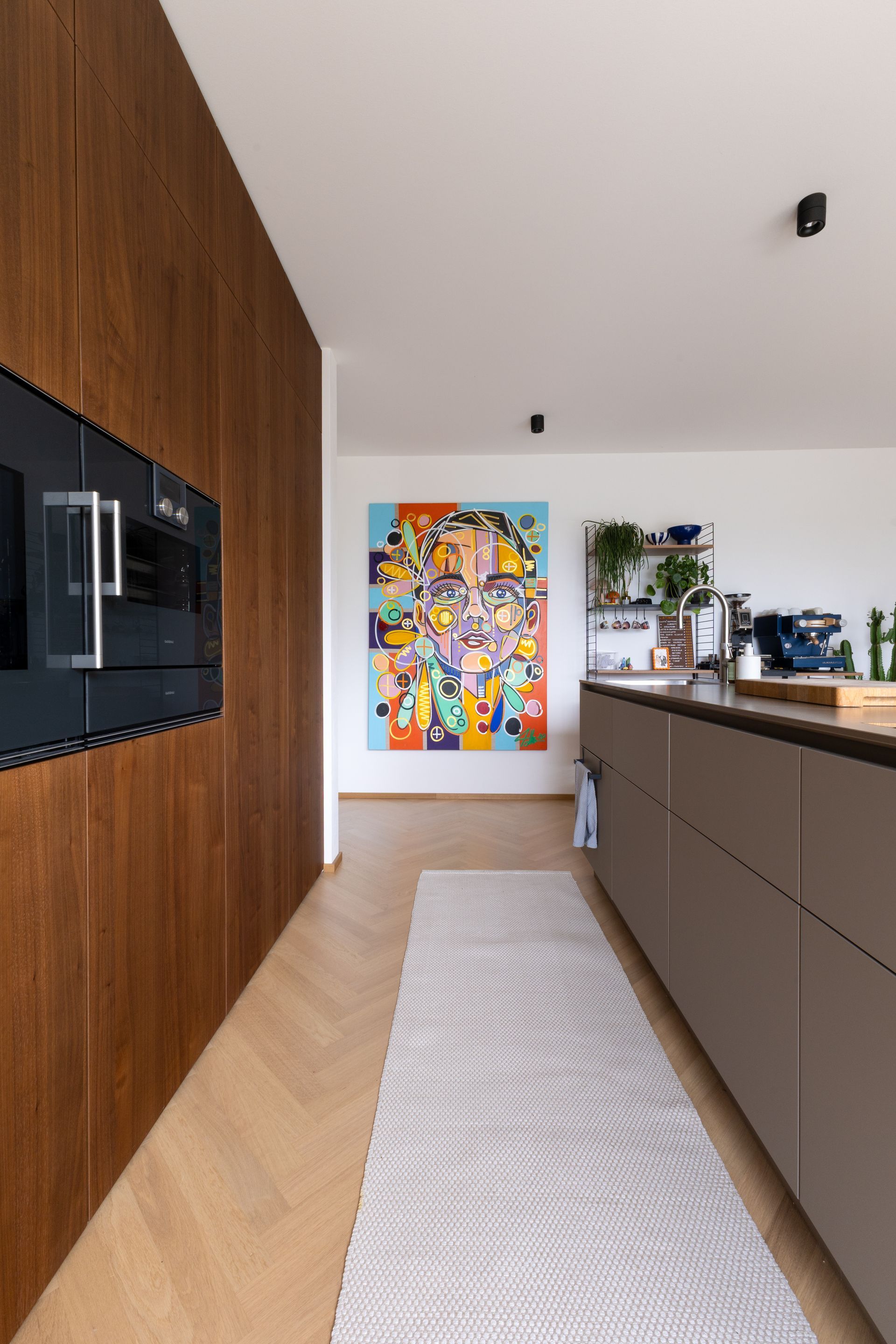 Moderne Kücheneinrichtung mit Holzvertäfelung, Kunst und einem Teppich.Fotograf Tübingen. Fotograf Reutlingen.