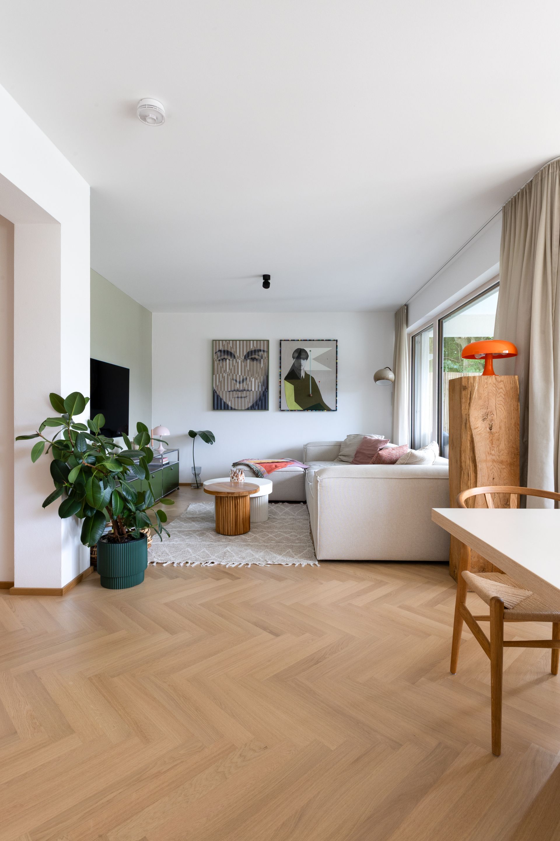 Wohnzimmer mit hellem Holzboden, Ecksofa, Kunstwerken und einer großen Pflanze.Fotograf Tübingen. Fotograf Reutlingen.