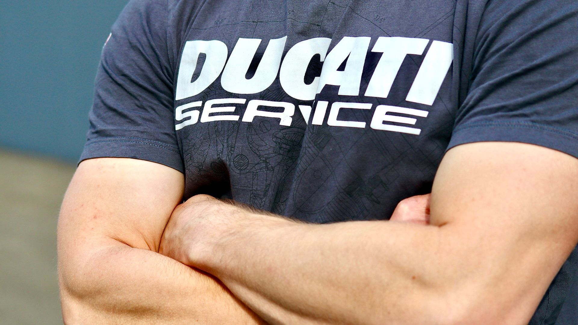 Person die ein dunkles T-Shirt mit der weißen Aufschrift „DUCATI SERVICE“ trägt.Fotograf Tübingen. Fotograf Reutlingen.