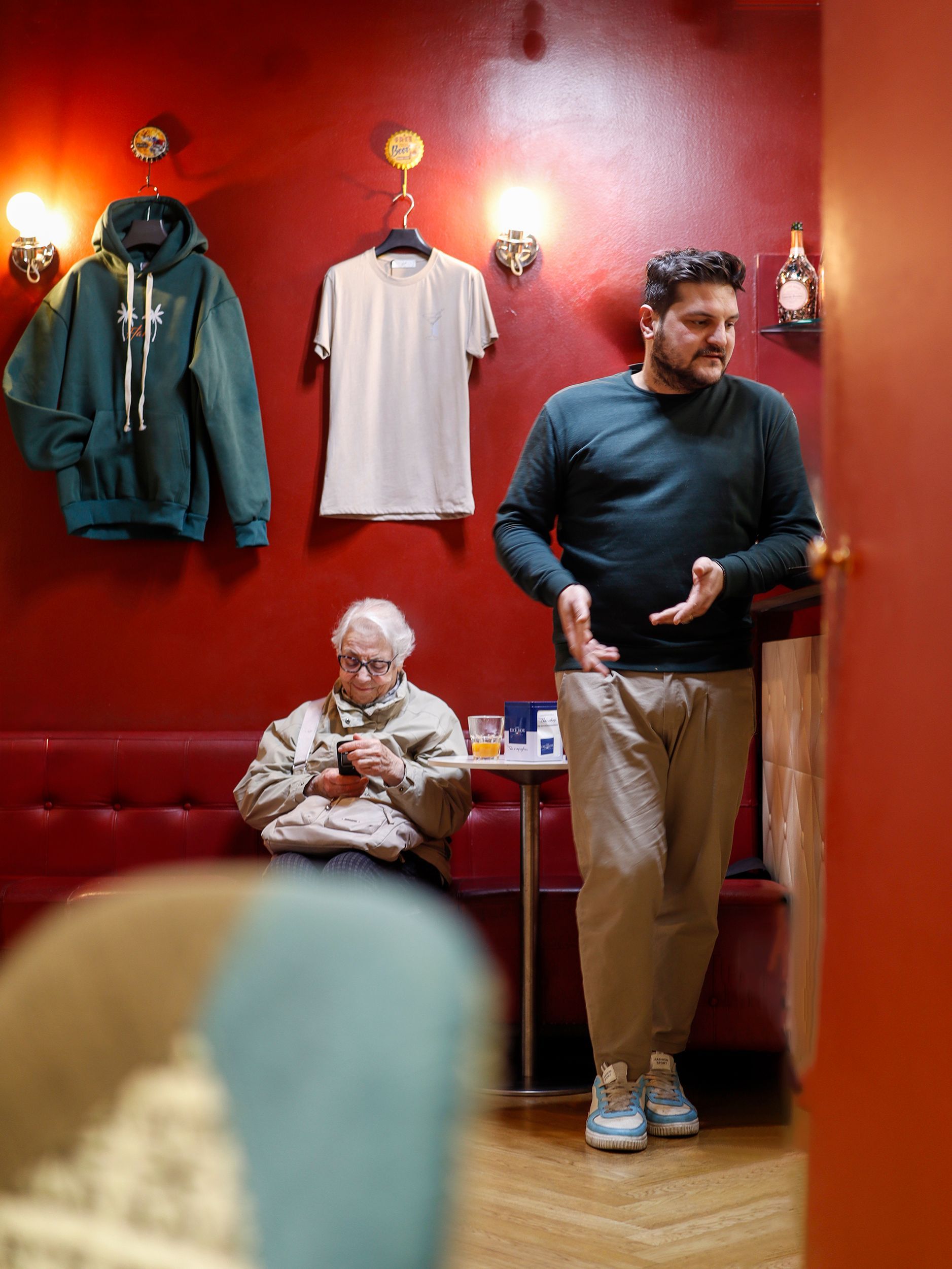 Ein Mann gestikuliert in der Nähe einer sitzenden Person in einer Bar. Fotograf Tübingen. Fotograf Reutlingen.