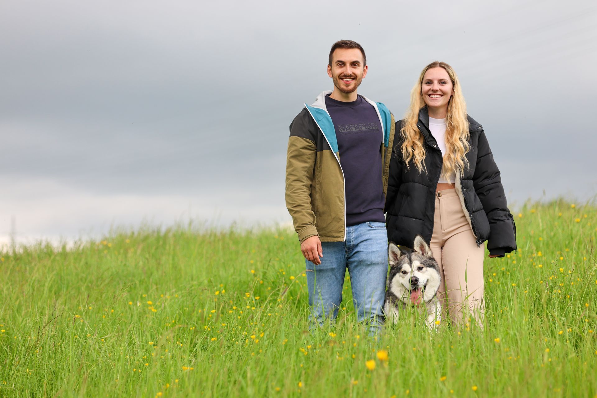 Ein Paar und Hund posieren auf einer Wiese unter bewölktem Himmel. Fotograf Tübingen. Fotograf Reutlingen.