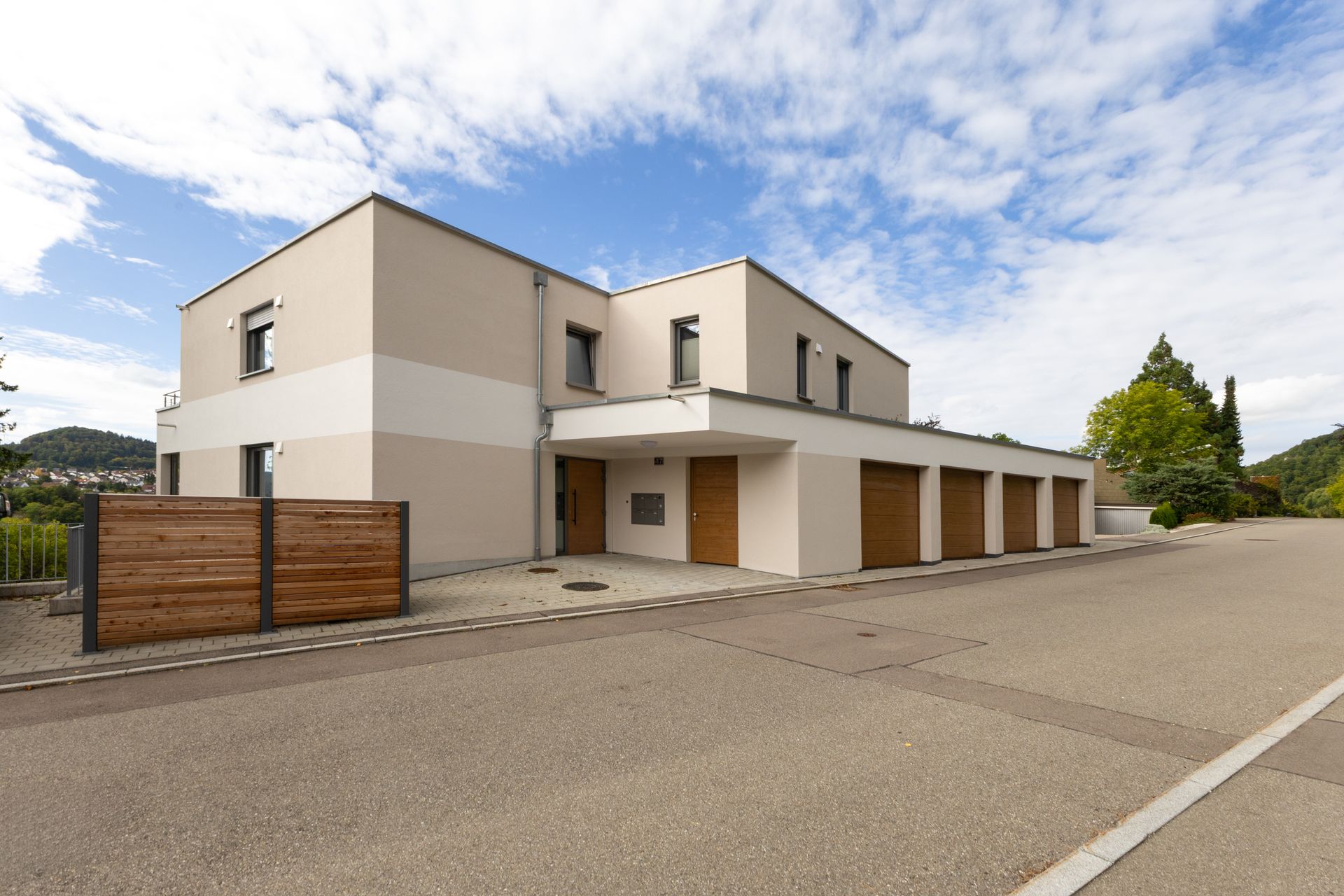 Modernes zweistöckiges Haus mit beiger Fassade, Garagentoren aus Holz. Fotograf Tübingen. Fotograf Reutlingen.