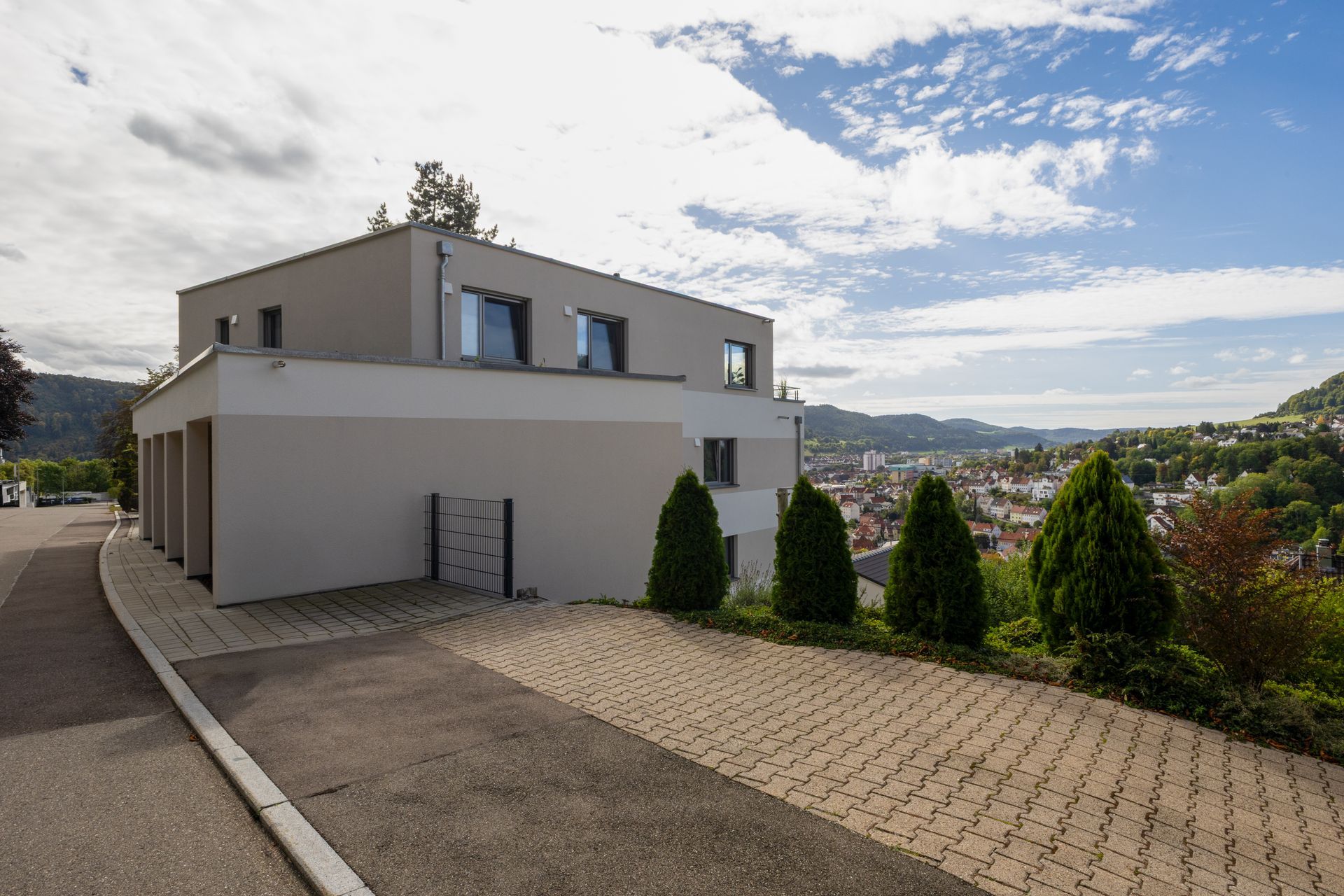 Modernes beiges Gebäude auf einem Hügel mit Blick auf die Stadt, Bäume.Fotograf Tübingen. Fotograf Reutlingen.