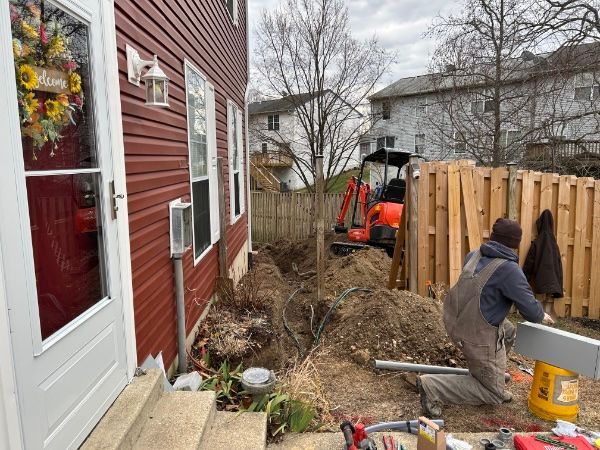 deck building contractor using excavation equipment.
