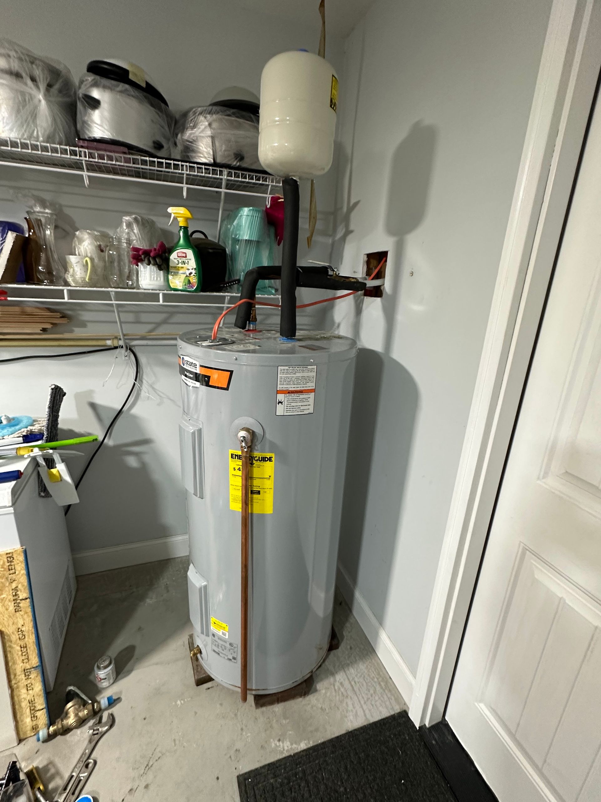 Water heater with expansion tank in a garage.