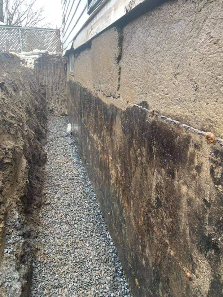 On travaille sur un mur de fondation, avec une tranchée de gravier.