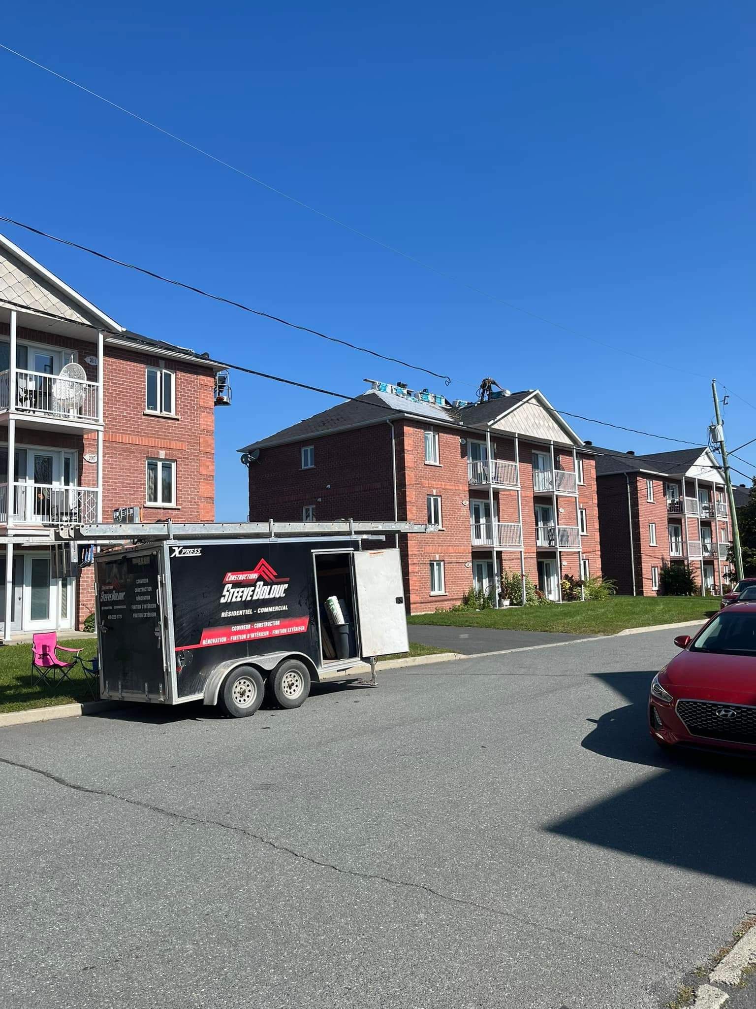 Une caravane garée devant des immeubles d'appartements en briques par une journée ensoleillée.