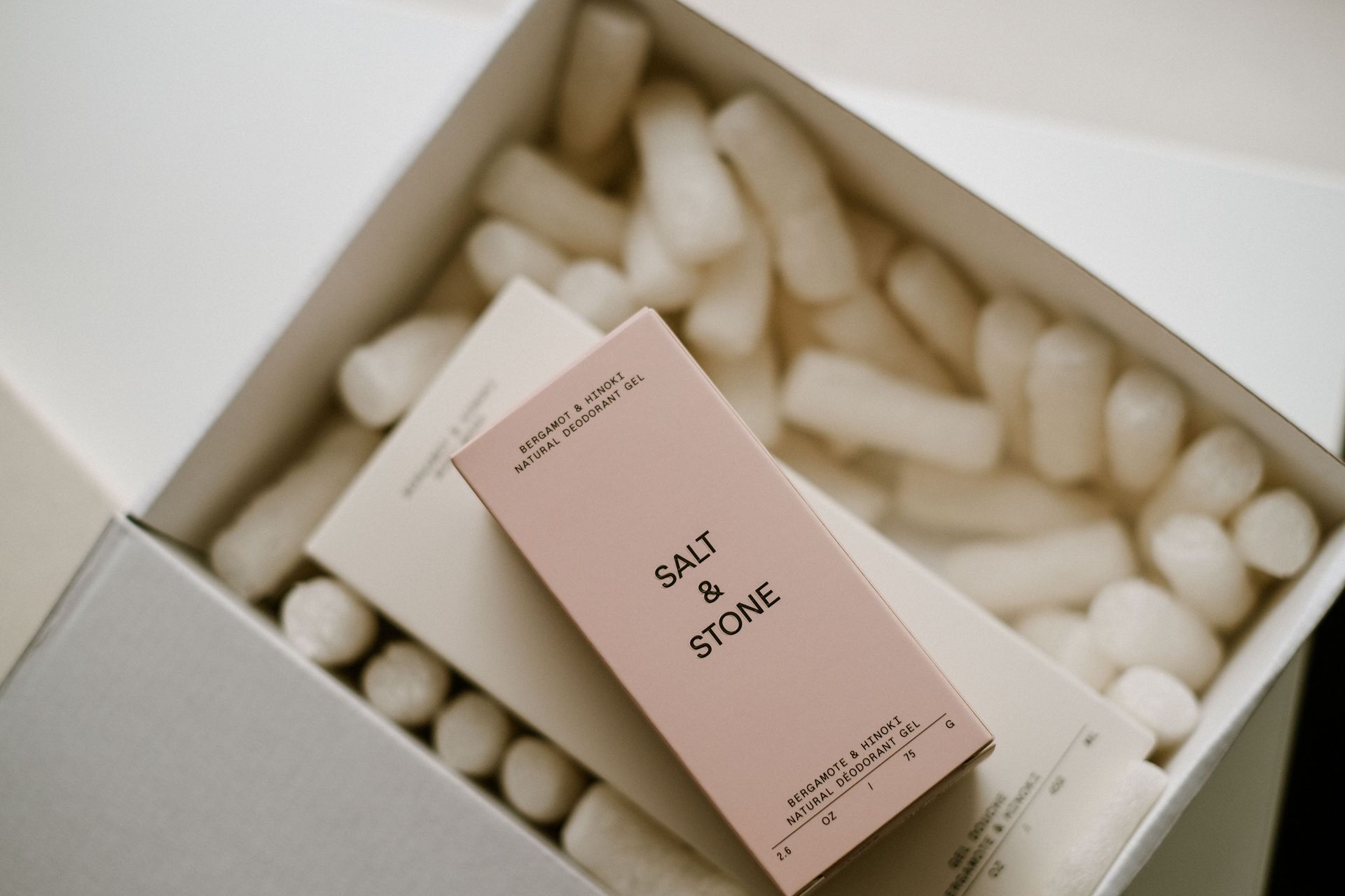 cosmetics in a white gift box filled with packing peanuts