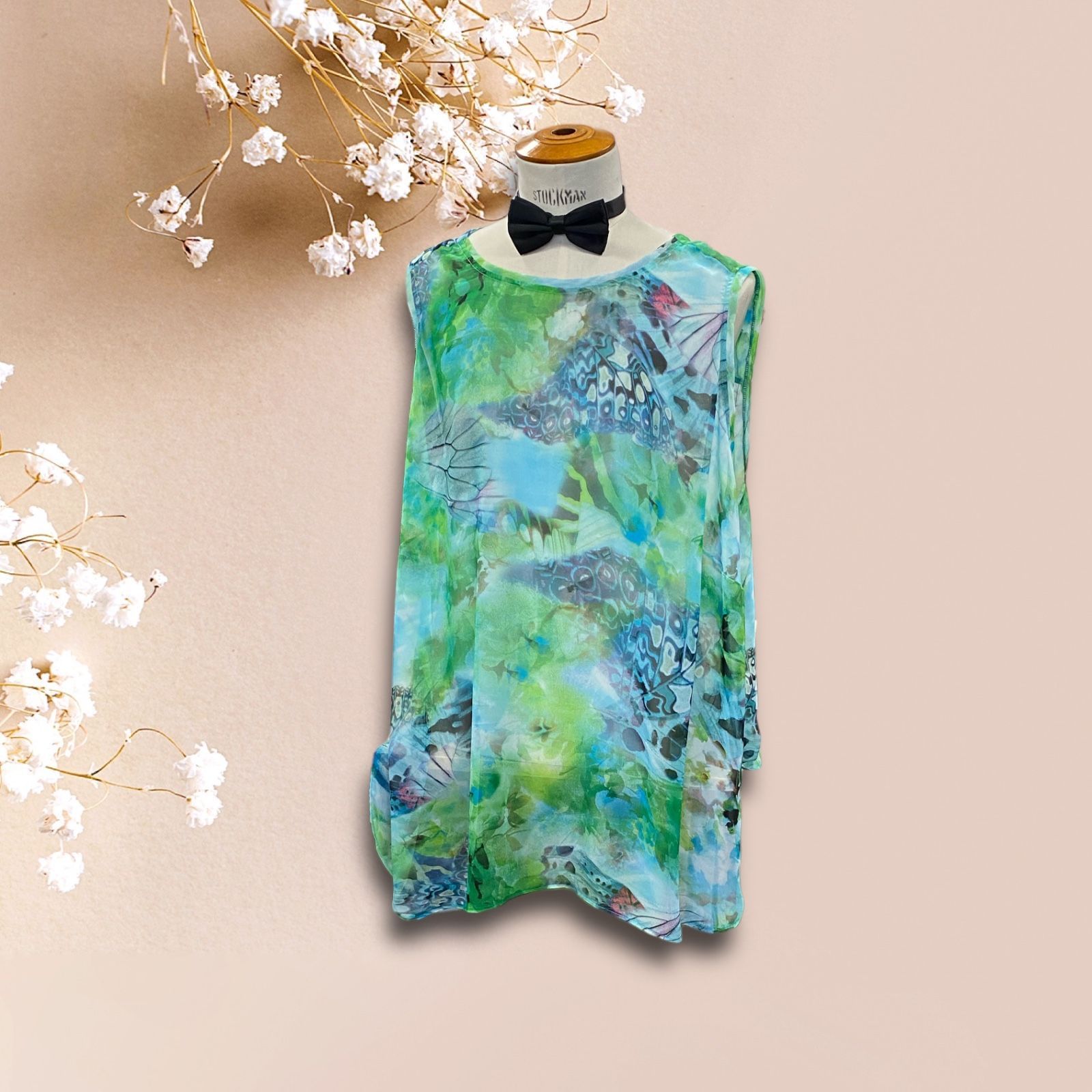 Une chemise verte avec un nœud papillon est sur un mannequin.
