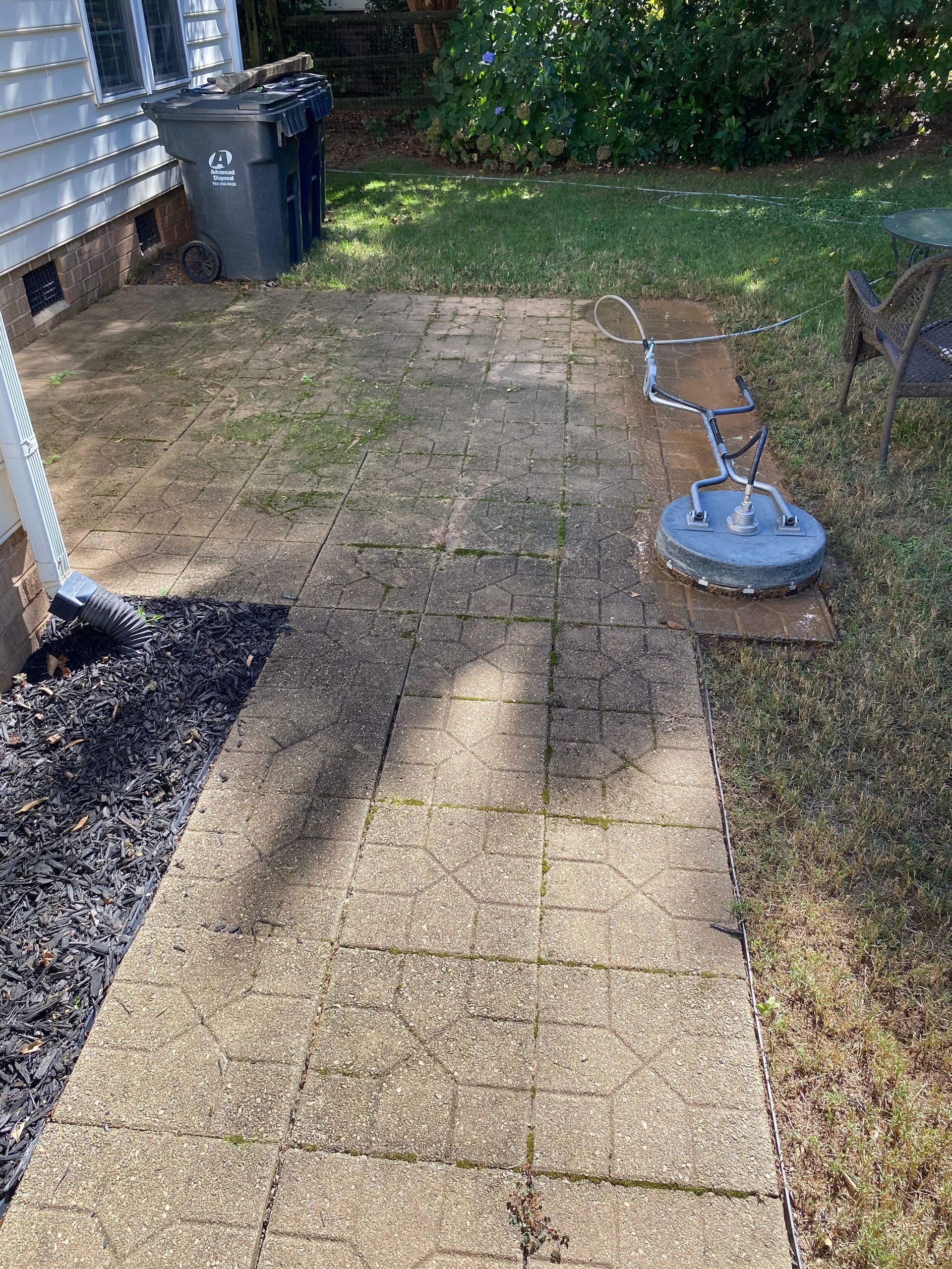 Windows Gutters LLC - A pathway being cleaned with a surface cleaner; part of it is clean, the rest is dirty.