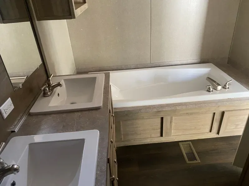 A bathroom with a tub , sink and mirror.
