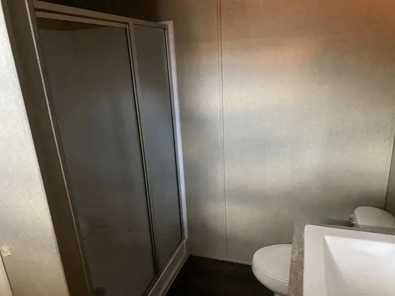 A bathroom with a toilet , sink and shower stall.