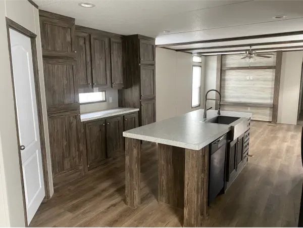 A kitchen with a large island and a sink in a mobile home.