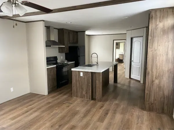 A kitchen with a large island and a ceiling fan
