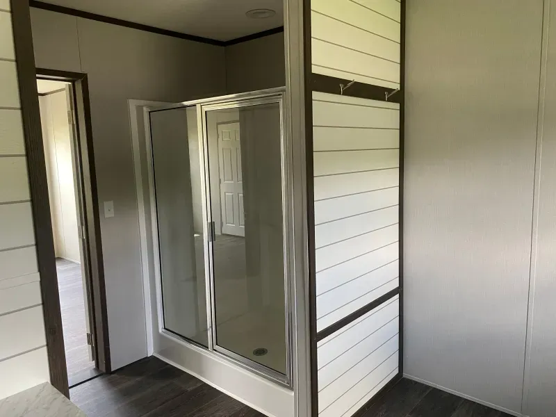 A bathroom with a walk in shower and a door.