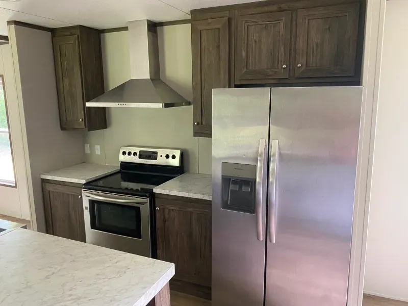 A kitchen with a stove , refrigerator , and microwave.