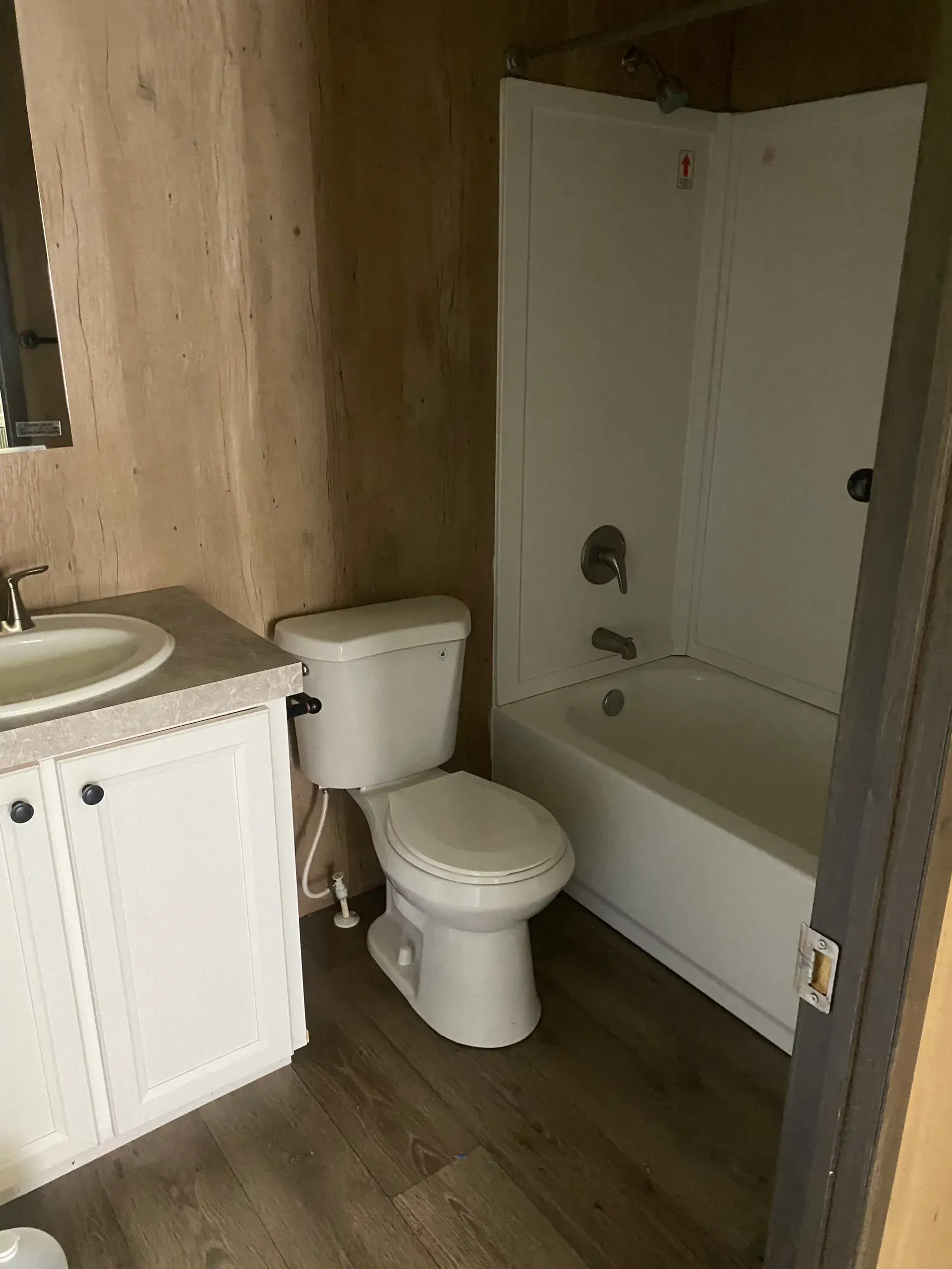 A bathroom with a toilet , sink and bathtub.