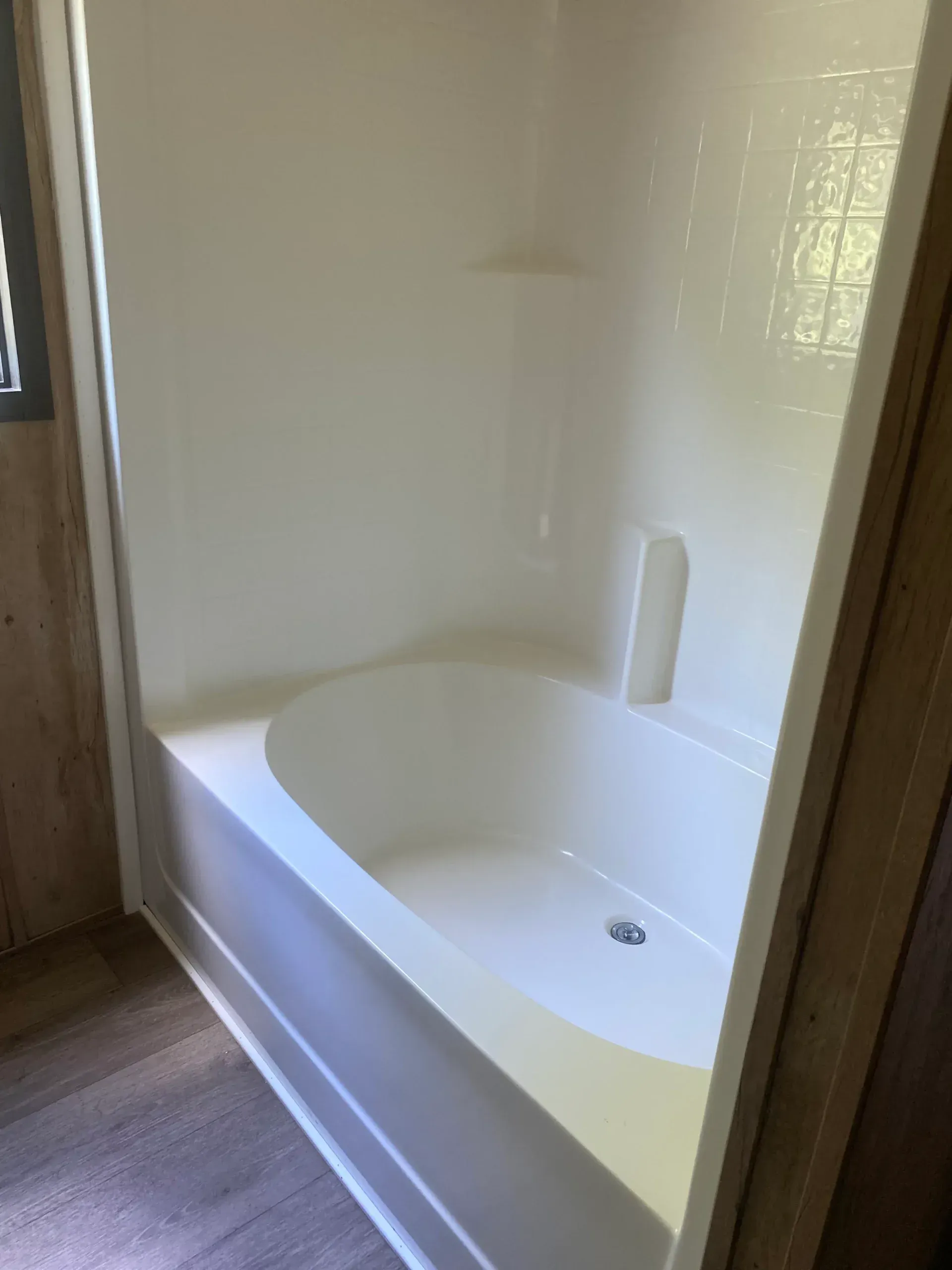 A white bathtub in a bathroom next to a shower stall.