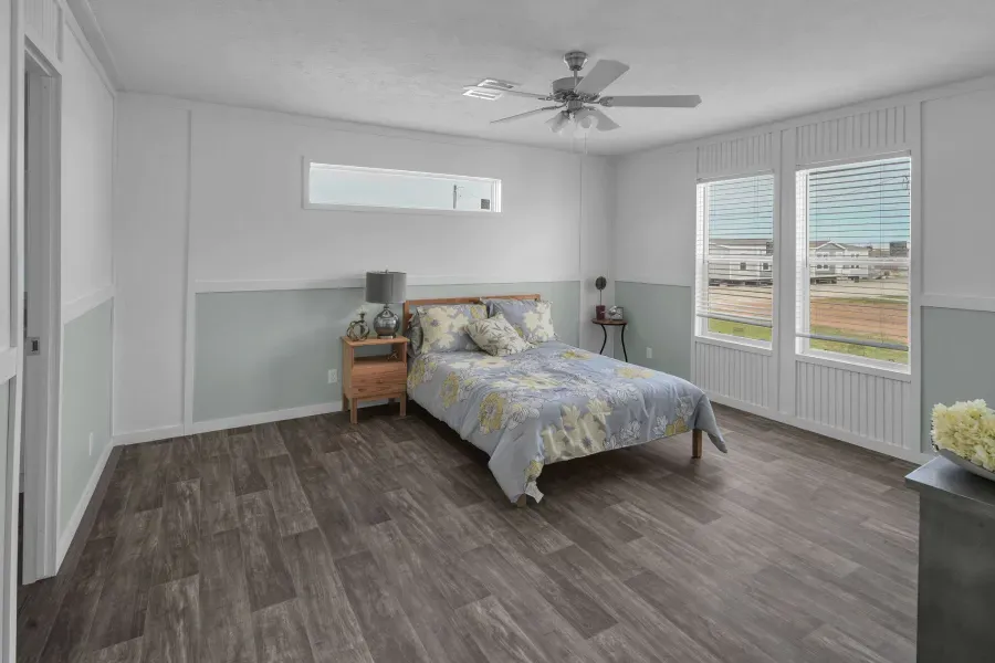 A bedroom with a bed , nightstand , and ceiling fan.