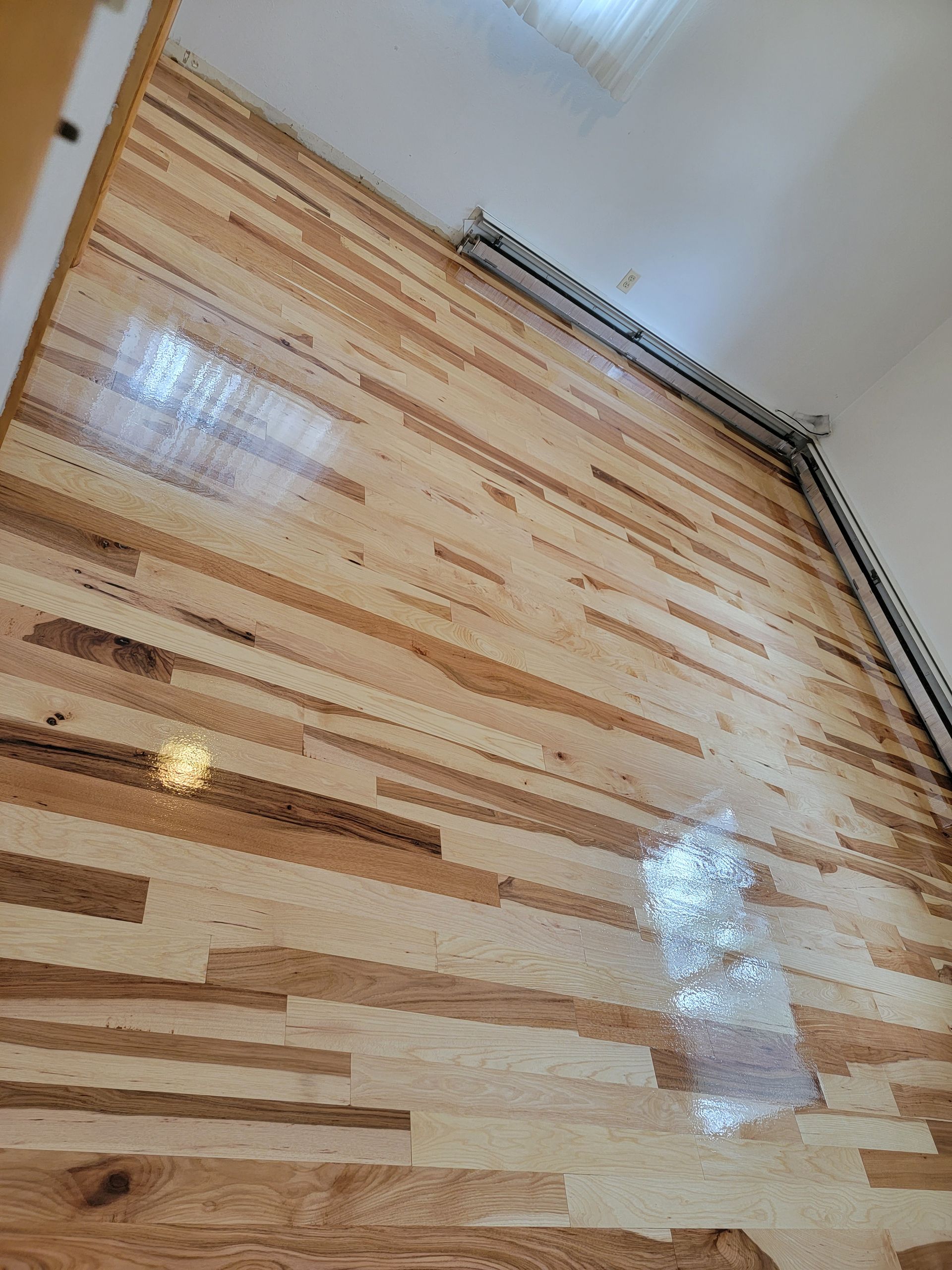 Wooden shutter or blind with alternating light and dark slats, viewed from below indoors