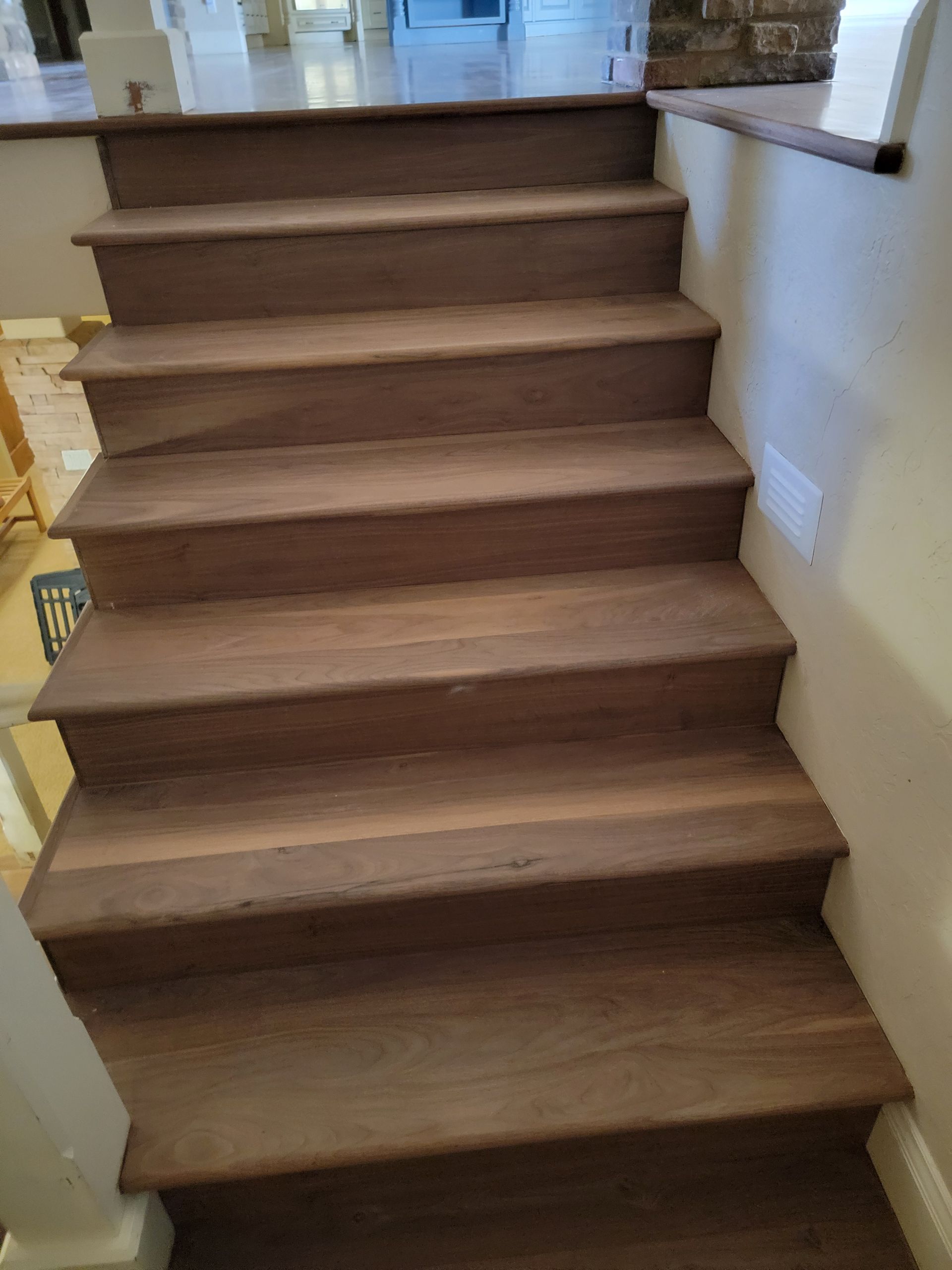 Indoor wooden staircase with carpeted steps and white walls