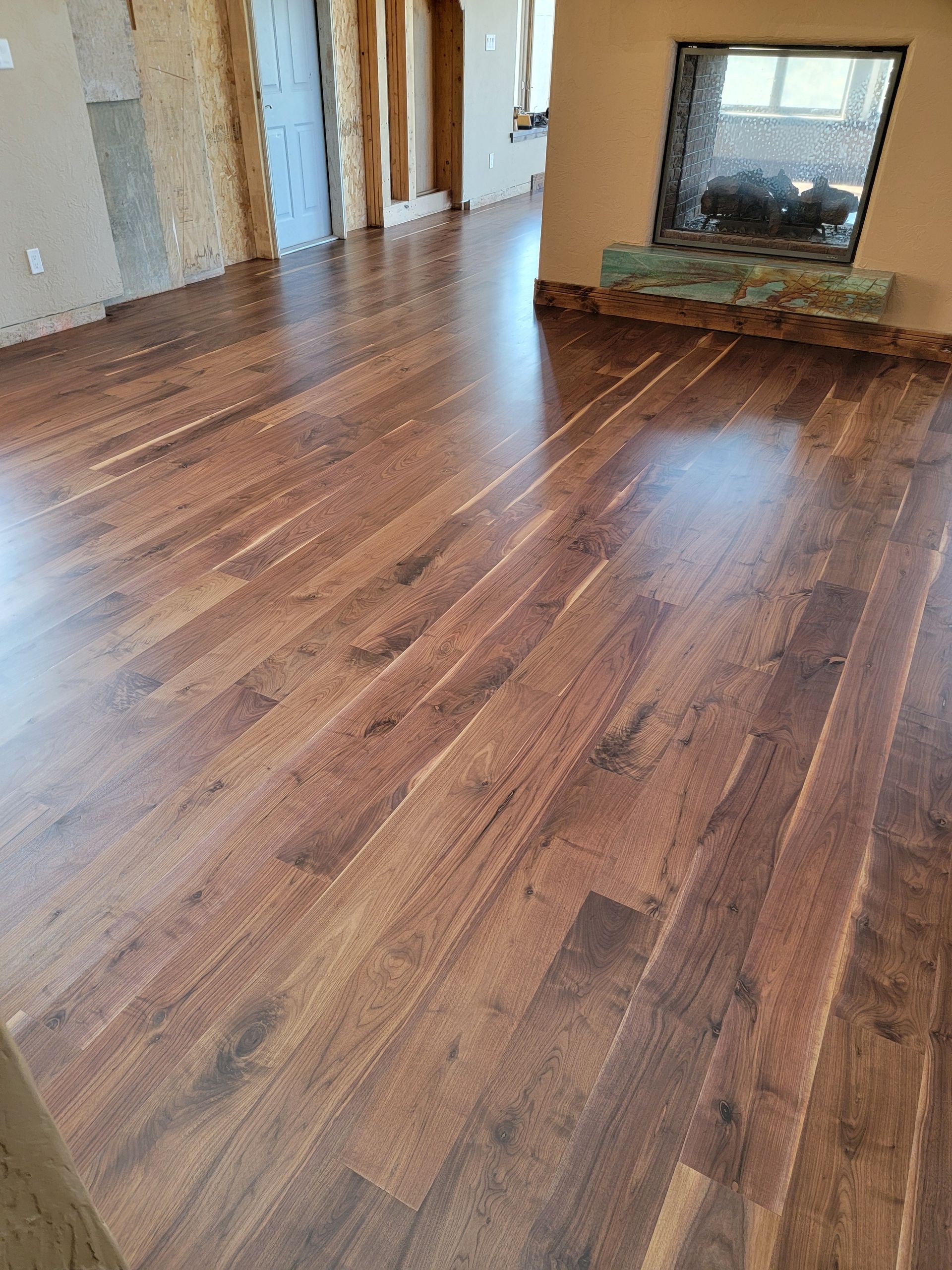 Empty room with polished hardwood floor and a fireplace on the far wall