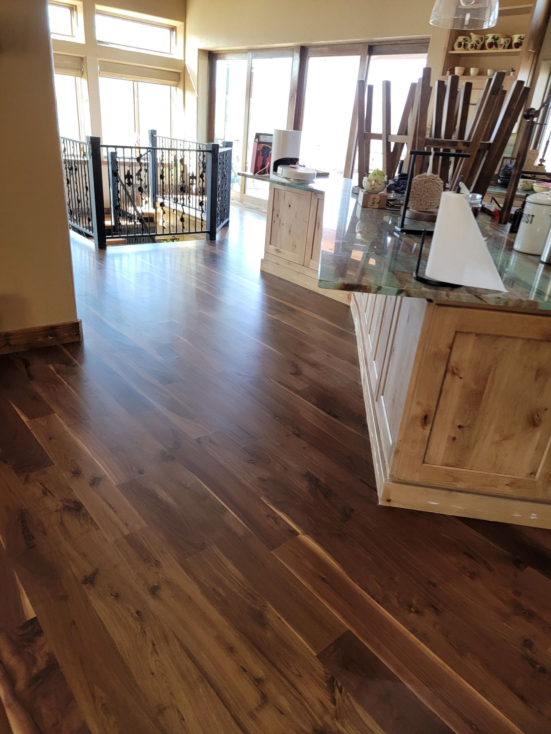 Empty storefront interior with wood floors, display tables, and sunlight through front windows