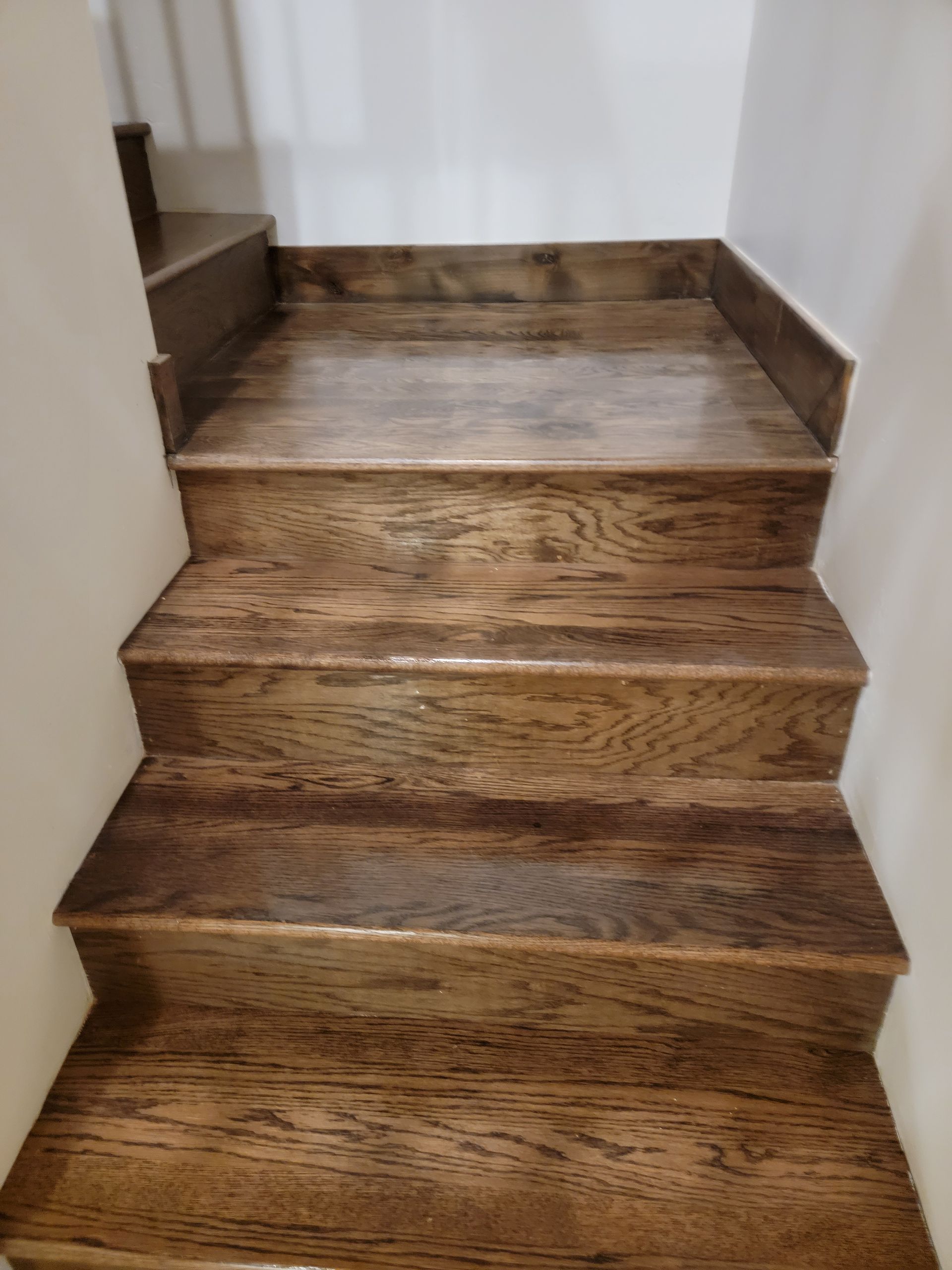 Wooden staircase with brown steps and white walls indoors