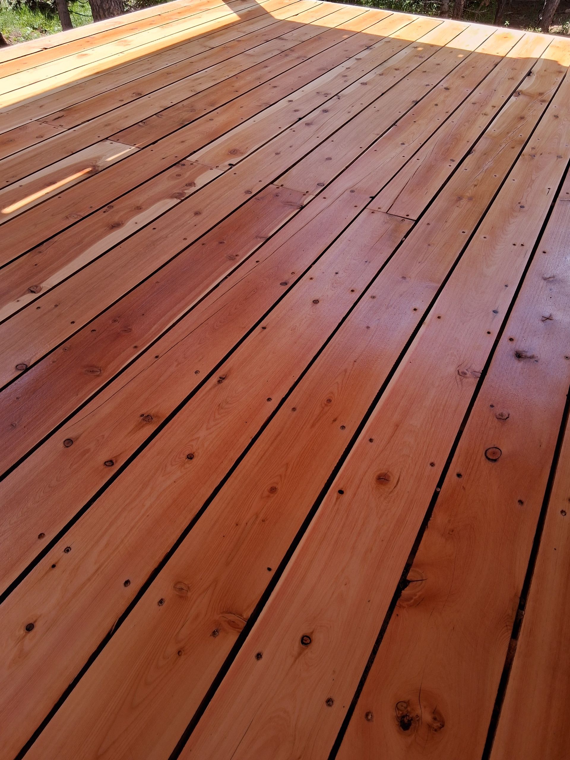 Wooden deck with reddish-brown planks receding into the distance