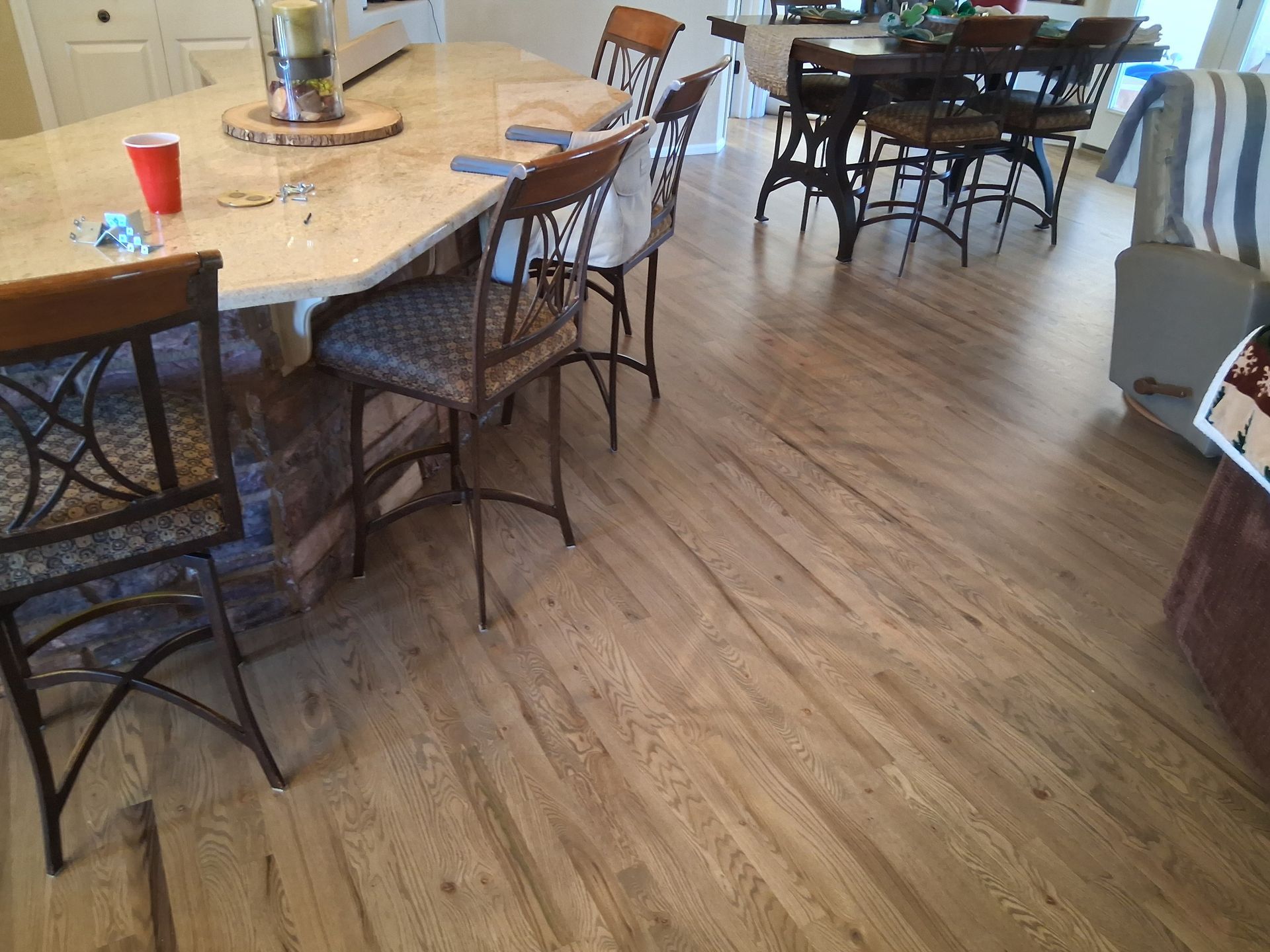 Dining room with round tables, wrought-iron chairs, and wood flooring
