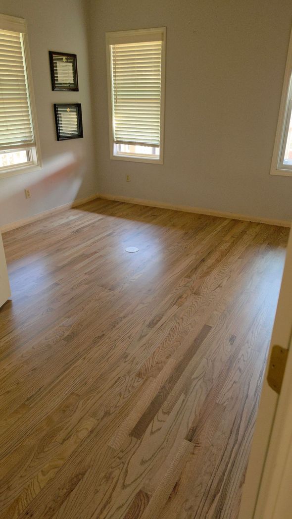 Empty room with light wood floors, beige walls, and windows letting in sunlight. Empty room with light wood floors, beige walls, and windows letting in sunlight.