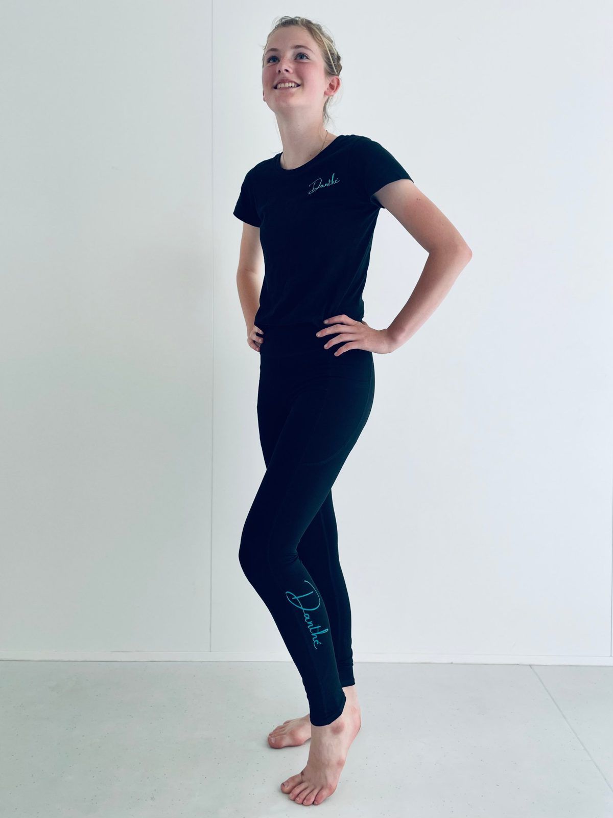 Een danseres in een zwart Danthé-T-shirt met het logo in groenblauw