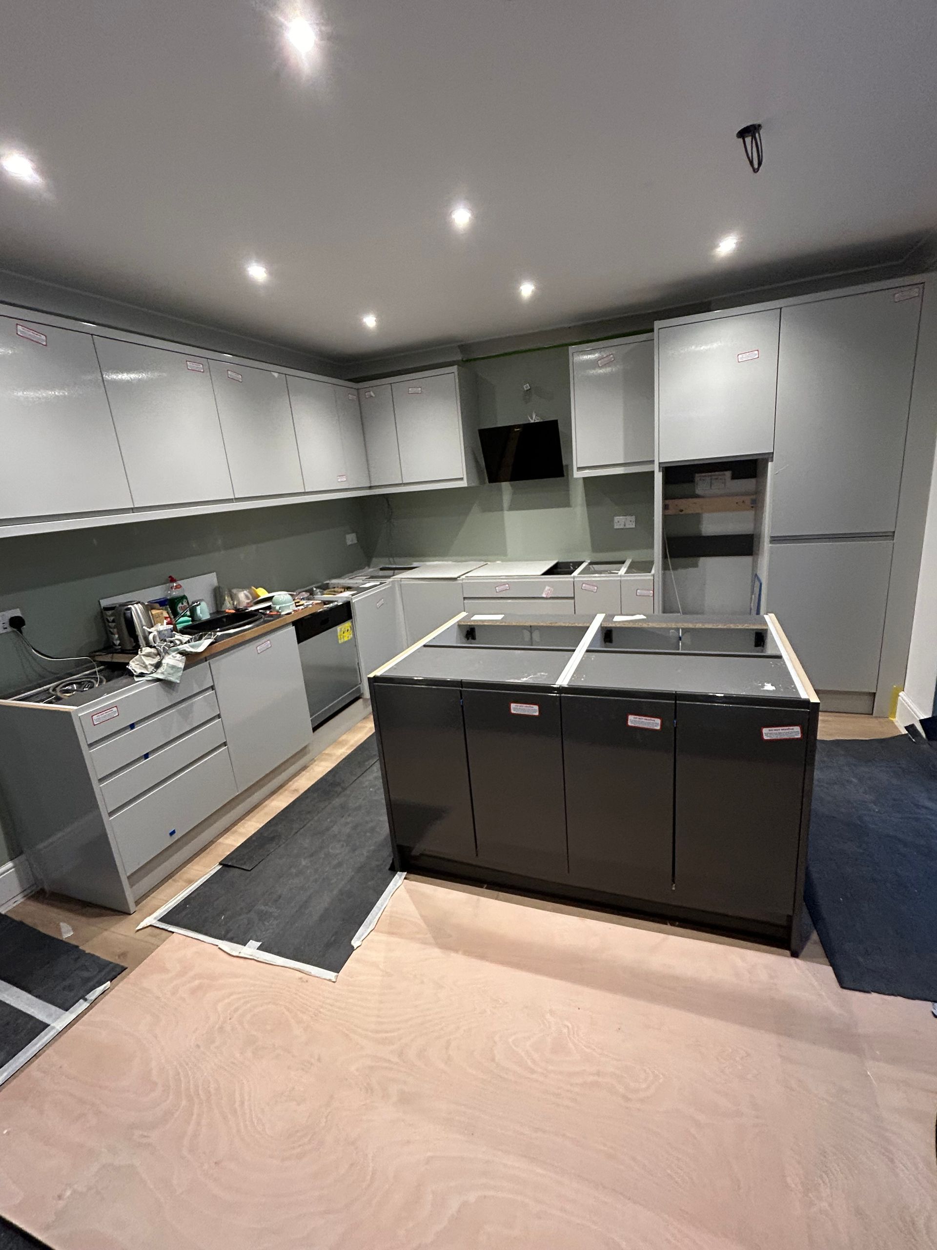 Modern kitchen with gray cabinets, island, and recessed ceiling lights