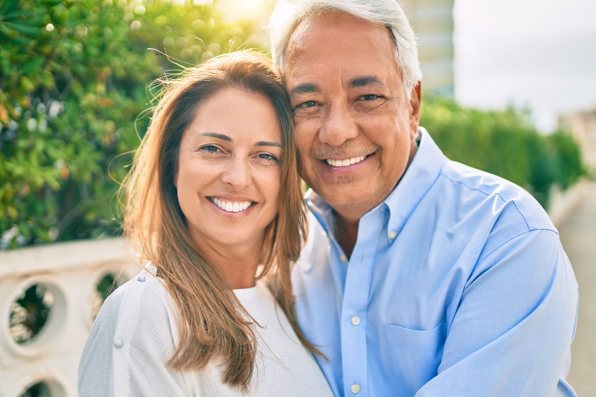 A man and a woman are posing for a picture and smiling for the camera.